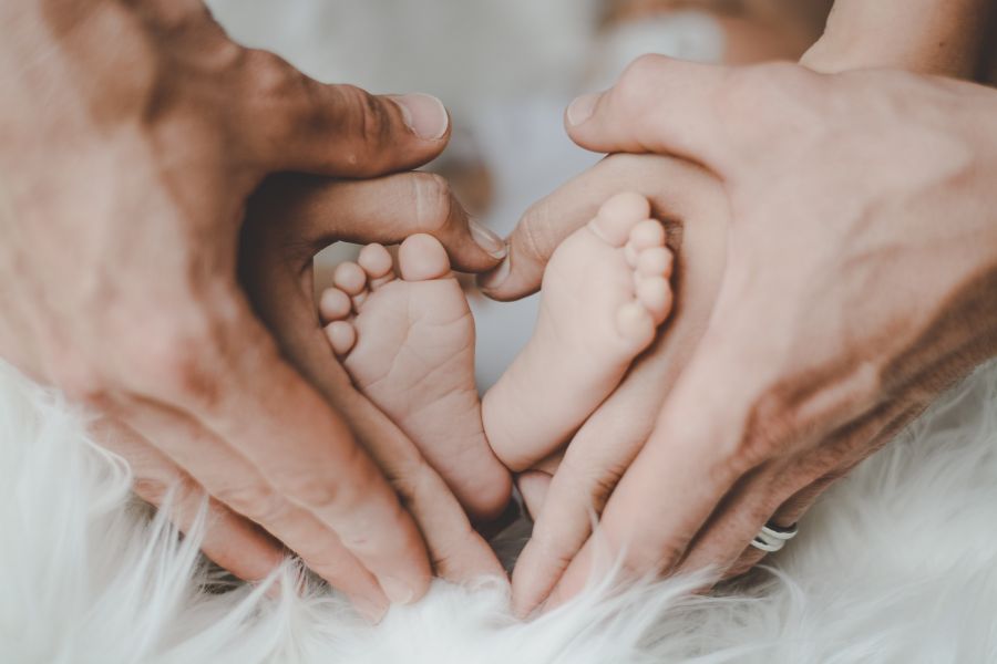 foto familiar con las manos de los padres y los pies del recién nacido